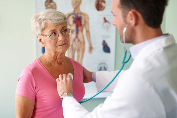 Medico con stetoscopio che controlla il torace di un paziente