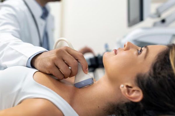 Approccio alla giovane donna esaminata da medici con scanner ad ultrasuoni in una clinica moderna