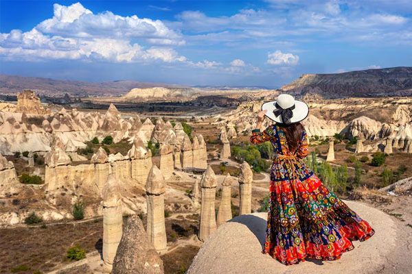 Donna in abito bohémien in piedi nella valle, Cappadocia Turchia