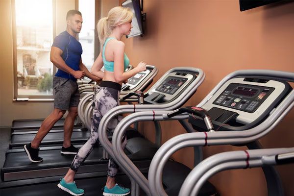 due persone che fanno cardio sui tapis roulant