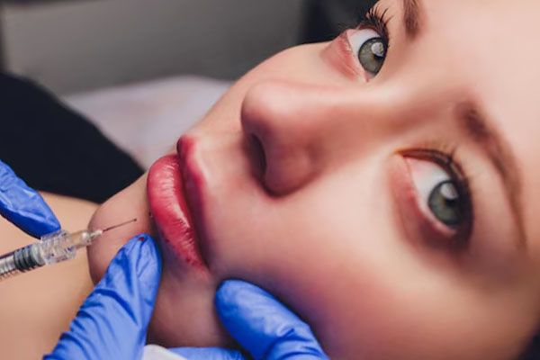giovane donna che riceve un'iniezione nelle labbra da vicino