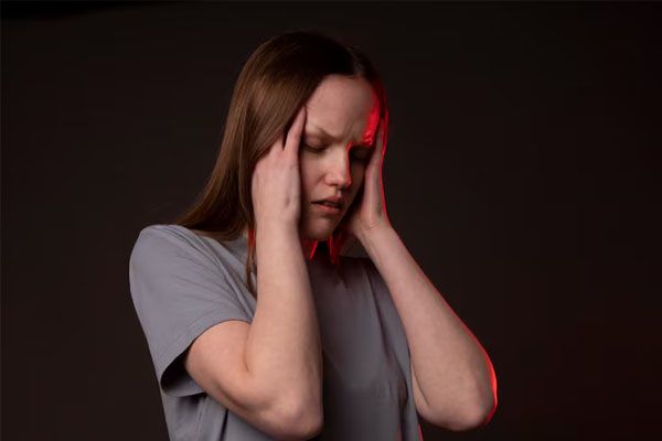 giovane donna con forte mal di testa che si tiene la tempia
