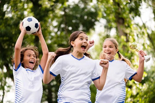 group of boys in soccer uniforms and with a ball