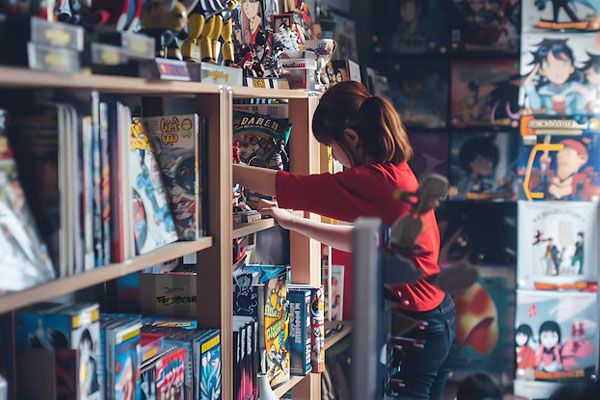 donna che sfoglia una libreria con libri colorati di anime e manga