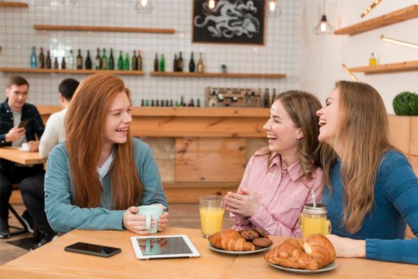 vista frontale di amici che fanno colazione insieme