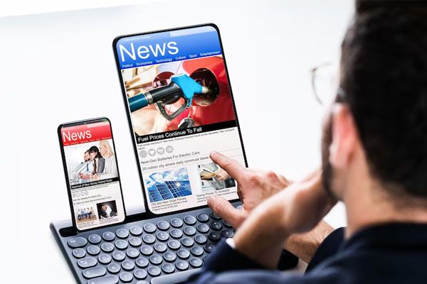 uomo di spalle che legge contenuti multimediali online su un computer portatile
