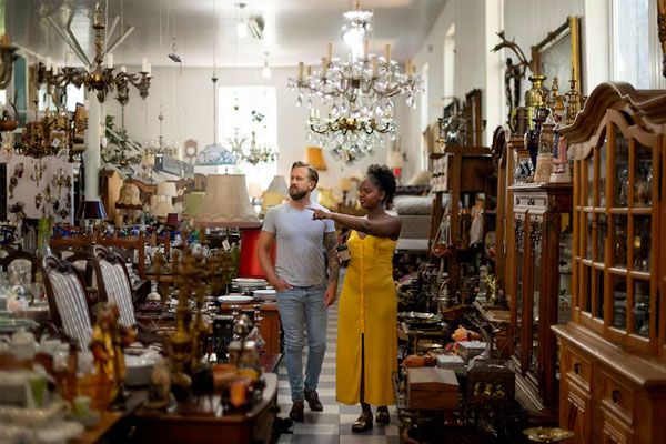 Persone che camminano tra le corsie di un negozio di antiquariato