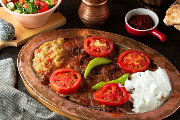 Piatto di kebab Iskender servito con insalata di melanzane e yogurt