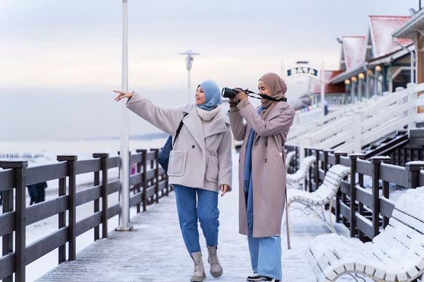 due amici musulmani camminano sull'oceano e scattano foto durante il viaggio