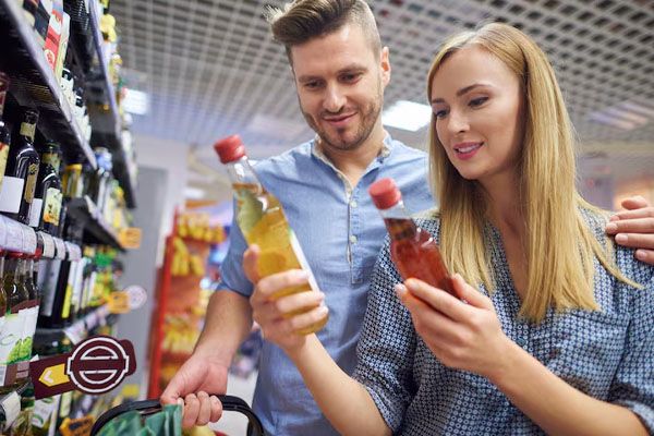 coppia che guarda i prodotti nel corridoio di un supermercato