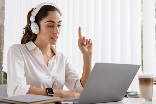 Giovane donna seduta alla scrivania davanti al computer portatile