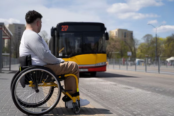 Uomo in sedia a rotelle in attesa dell'autobus