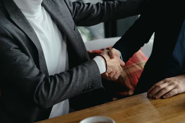primo piano due uomini che stringono la mano in un ufficio