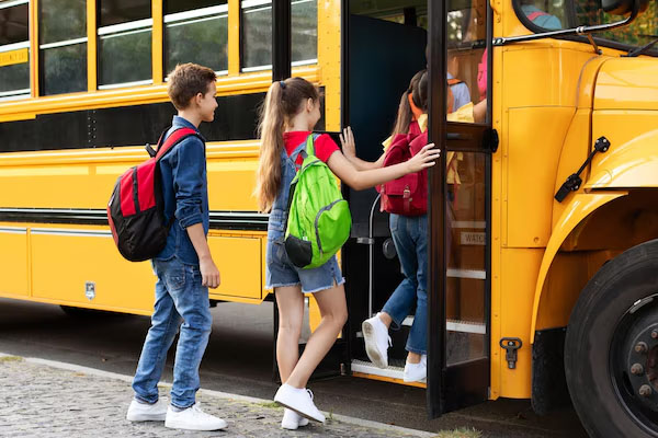 Bambini che salgono su uno scuolabus