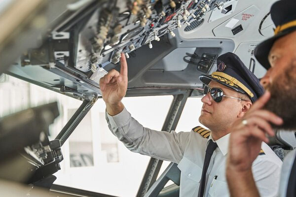Un uomo indica gli strumenti nella cabina di pilotaggio di un aereo