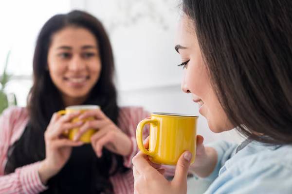persone che tengono in mano una tazza di tè