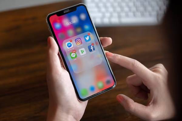 mani di una persona che tiene un telefono cellulare