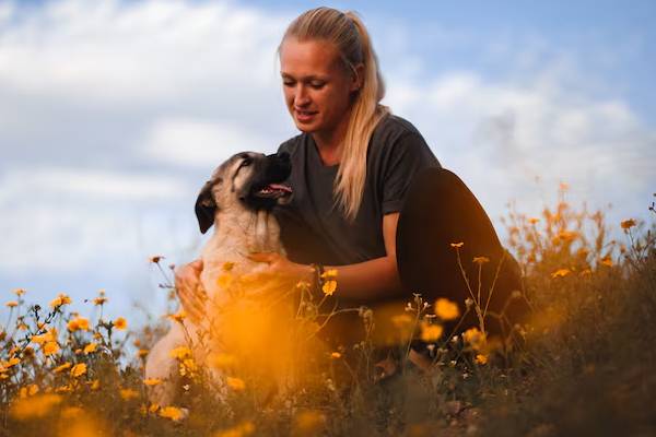 persona che trascorre del tempo con il proprio cane in campagna